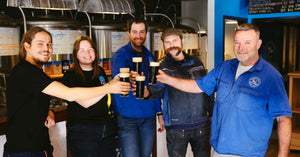 Brewers cheersing with an oatmeal stout