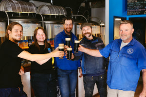 Brewers cheersing with an oatmeal stout